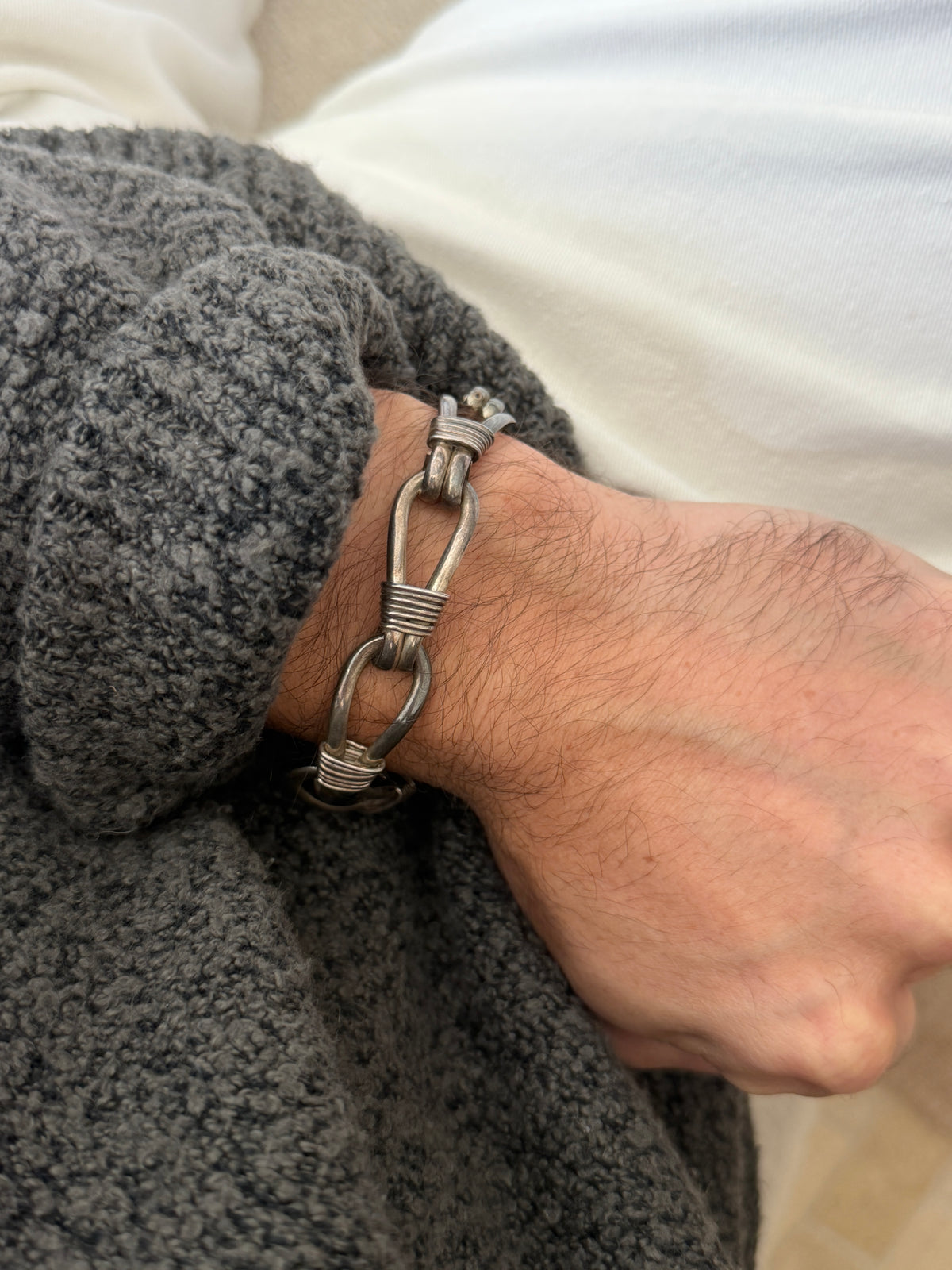 Wrist view of the nautical rope link bracelet in soft daylight, the open teardrop loops and wrapped joints in a continuous chain