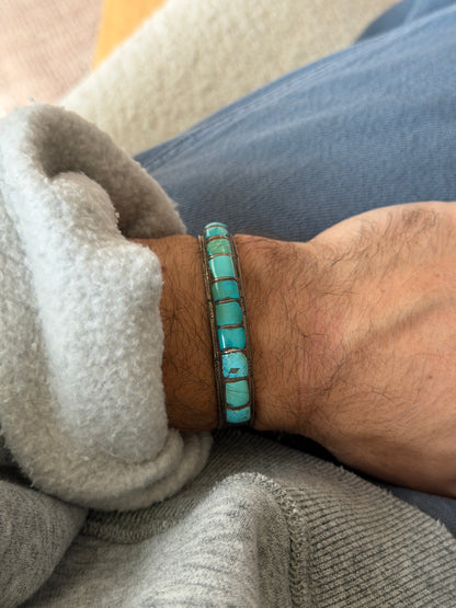 Cuff worn on the wrist against blue jeans and a grey sweatshirt cuff