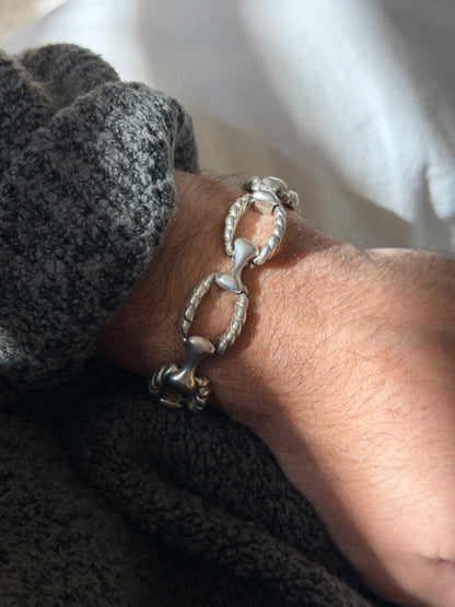 Angled wrist view of the sterling rope link bracelet, showing the hinged joint where each bone connector meets the twisted oval